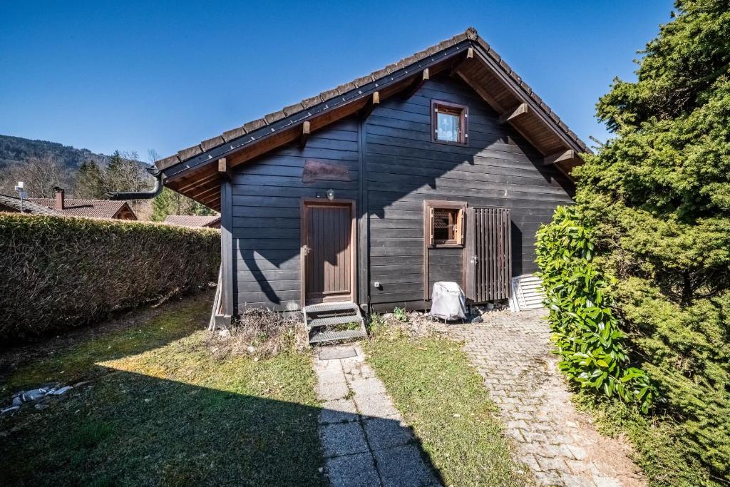 a small wooden house with a yard at Chalet 6p Classique - Les Biches in Verchaix