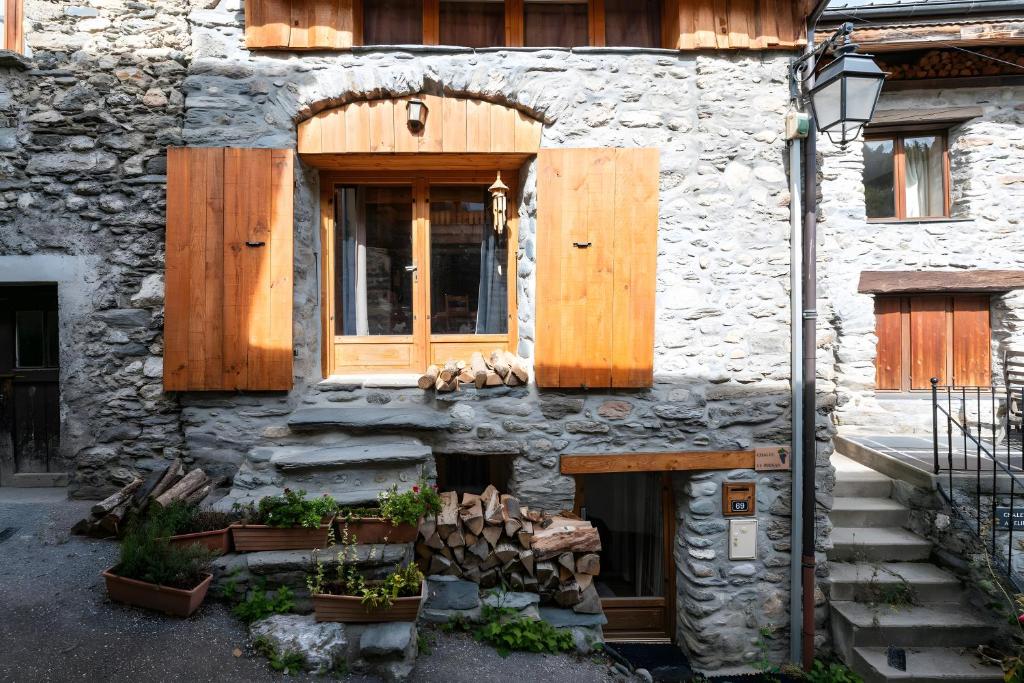 a stone building with a wooden door and a window at Chambre d'hôte Chalet le Persan in Courchevel