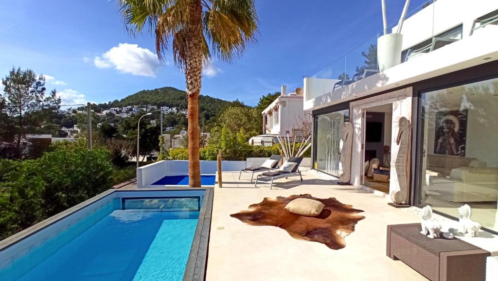 a villa with a swimming pool and a house at Villa La Vida in Cala Llonga