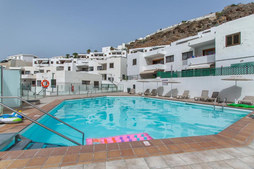 a large swimming pool in front of white buildings at Eucalipto-Sun guaranteed-pool wifi in Puerto Rico de Gran Canaria