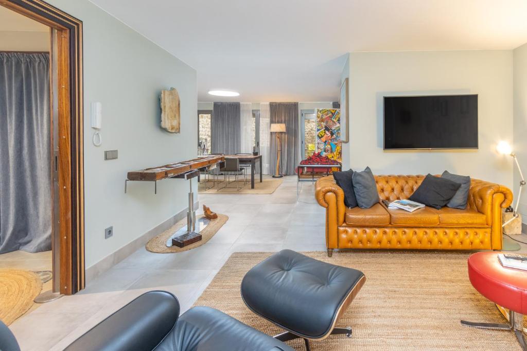 a living room with a couch and a flat screen tv at Kel Domènech Luxury Apartment in Besalú