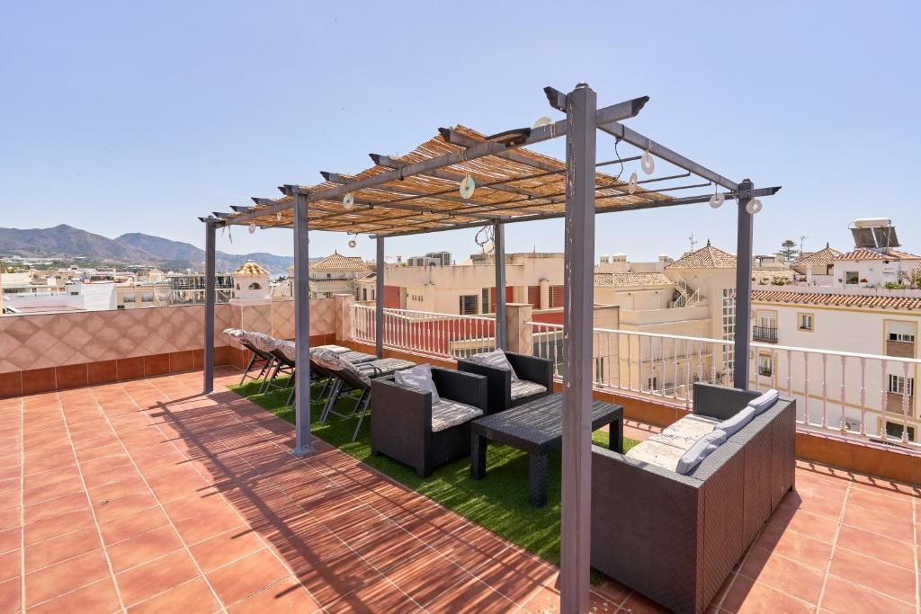 a patio with a pergola on a roof at Dúplex céntrico, 2 grandes terrazas in Nerja