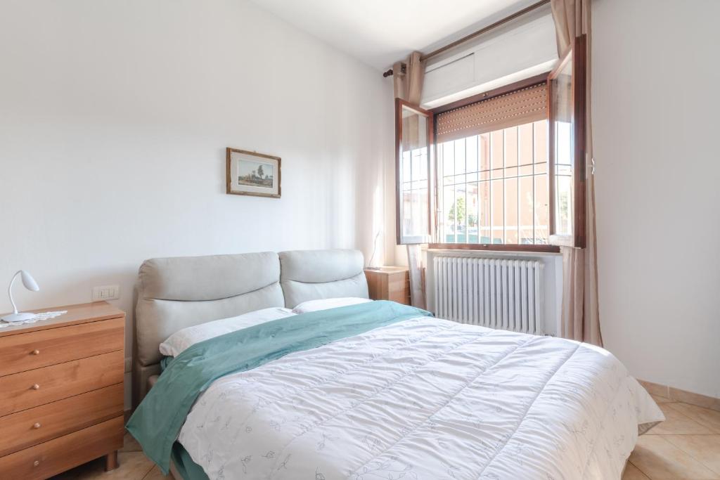 a white bedroom with a bed and a window at Casa Belvedere in Foiano della Chiana