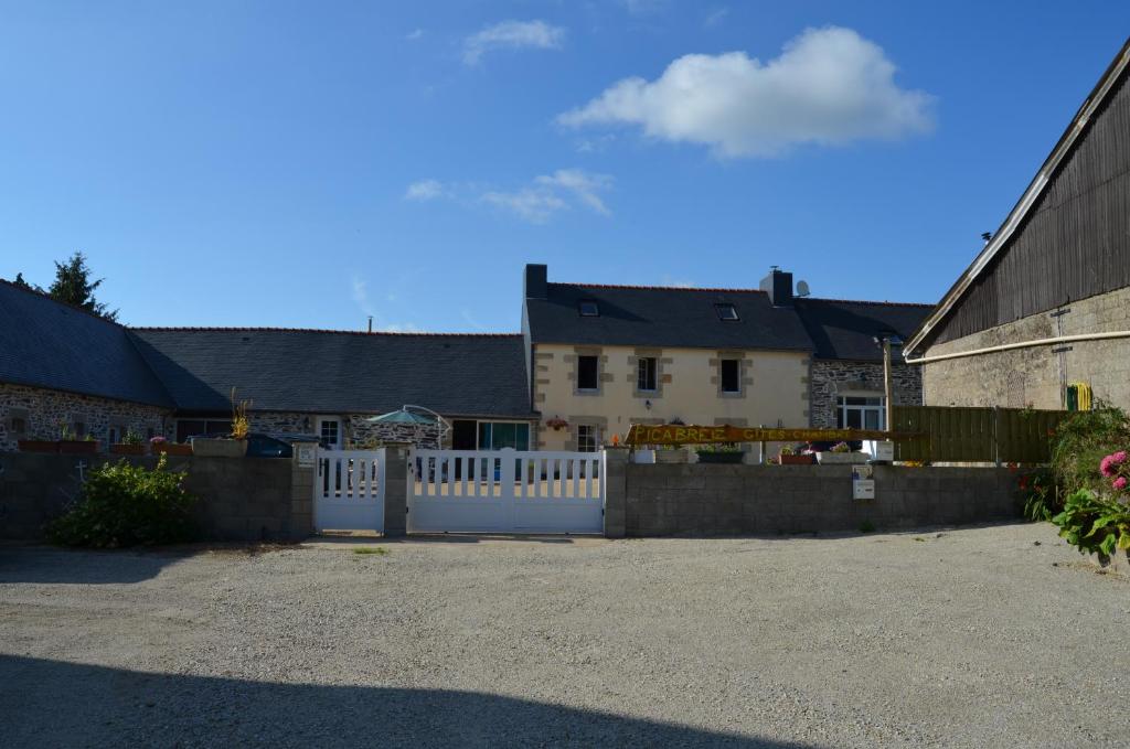 a white fence in front of a house at Chambre Breizh in Cast