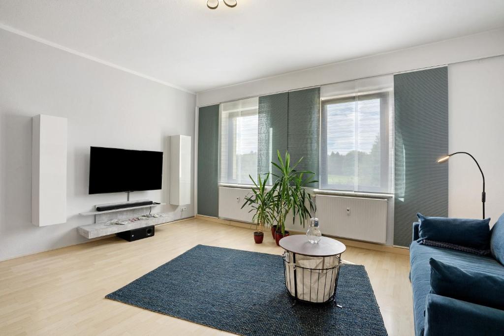 a living room with a blue couch and a tv at Ferienwohnung Spree - Oase in Spremberg