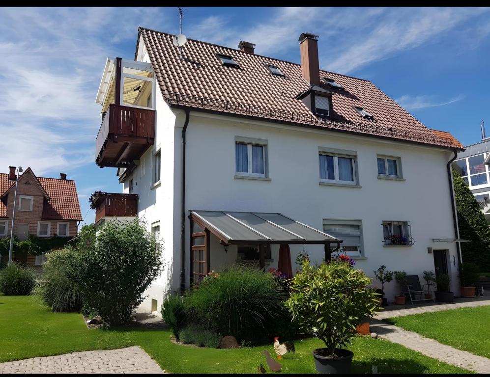 a white house with a red roof at Ferienwohnungen Michael u Christine in Langenargen