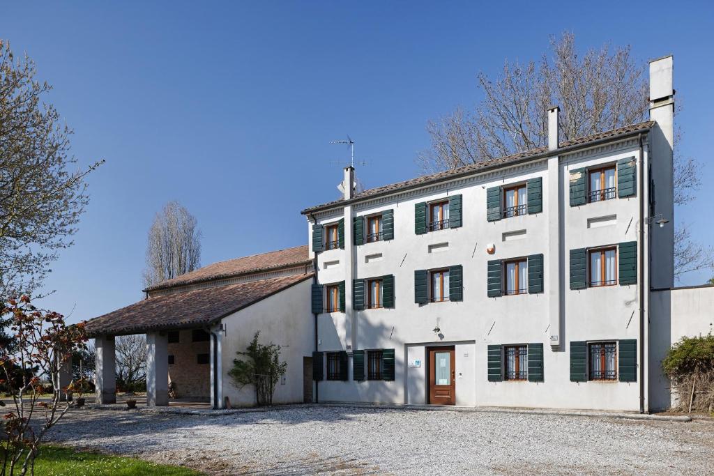 a large white building with a brown door at Agriturismo Marzanino in Torre di Mosto