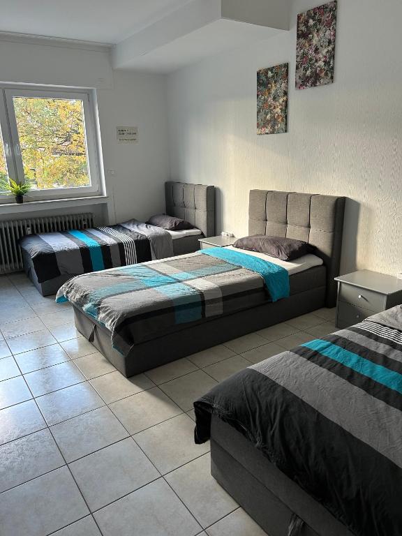 a room with three beds and a window at Minas Ferienwohnung in Dormagen
