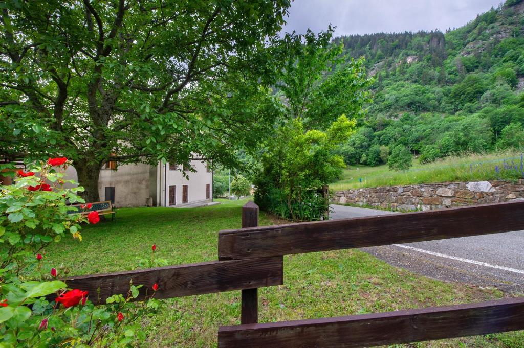 a wooden fence next to a road with flowers at Luéisch Ketschu near Gressoney in Issime