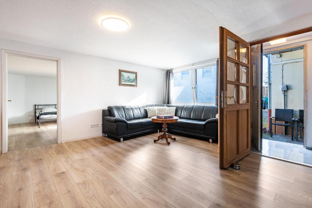 a living room with a black leather couch and a table at Ferien- Monteurwohnung in Nürnberg in Nuremberg