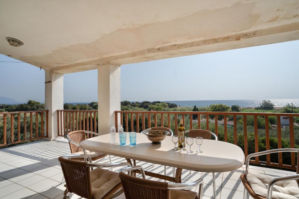 a white table and chairs on a deck with a view at Villa Sugar Town in Zacharo
