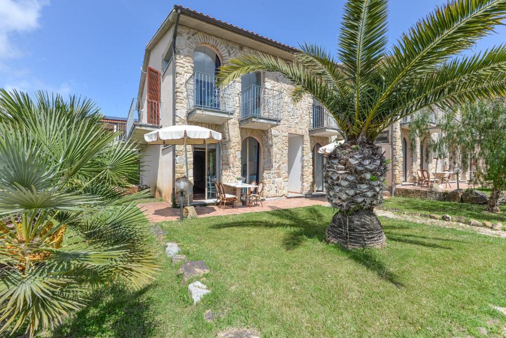 a palm tree in front of a house at Appartamenti Castle in Campo nell'Elba