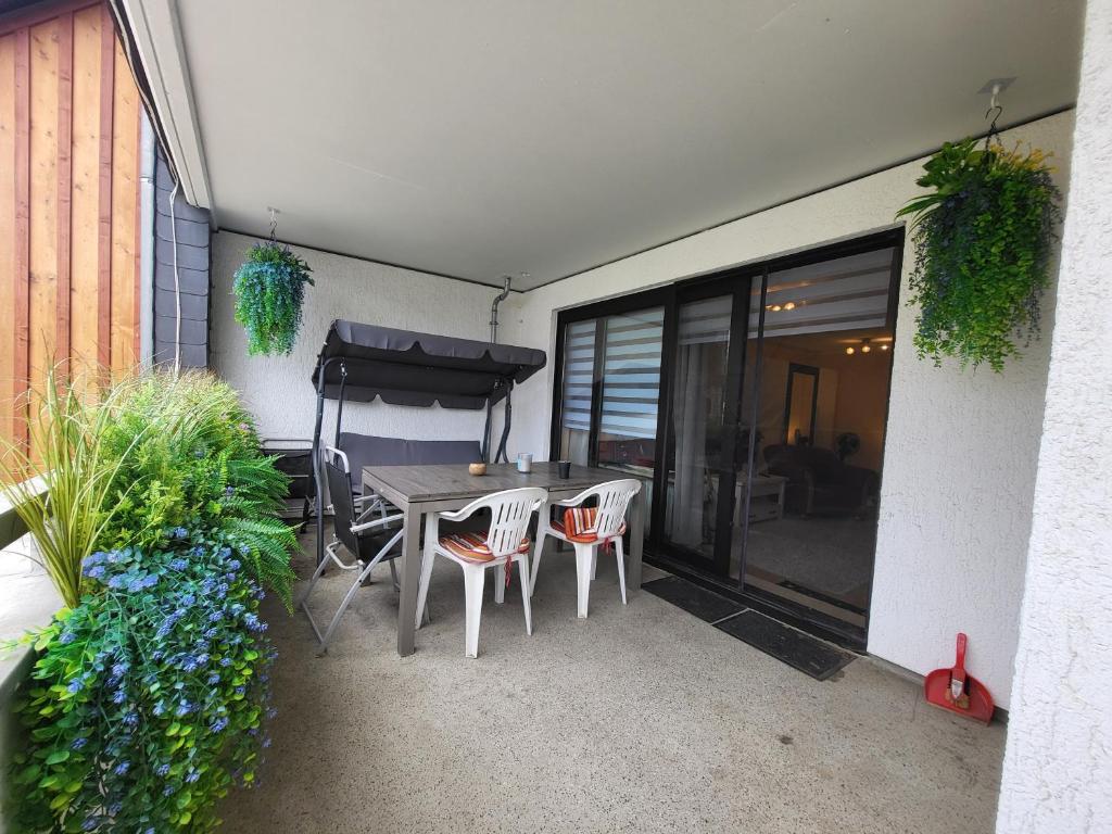 a patio with a table and chairs and a bed at Ferienwohnung Kleine Bergluft Hahnenklee in Hahnenklee-Bockswiese