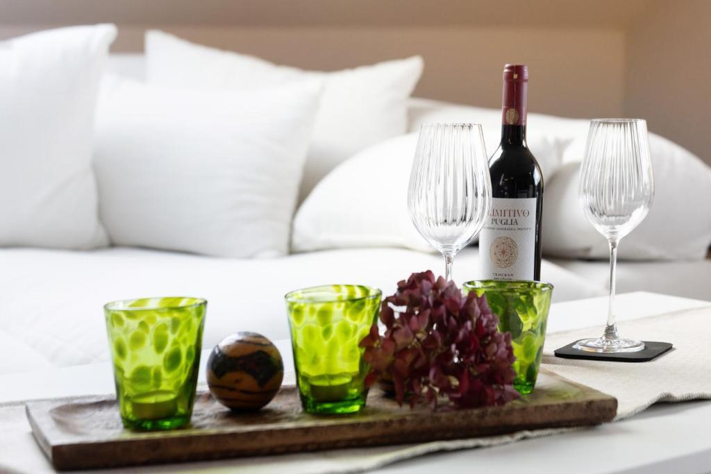 a table with a bottle of wine and glasses on a bed at Ferienwohnung Obrighoven in Wesel