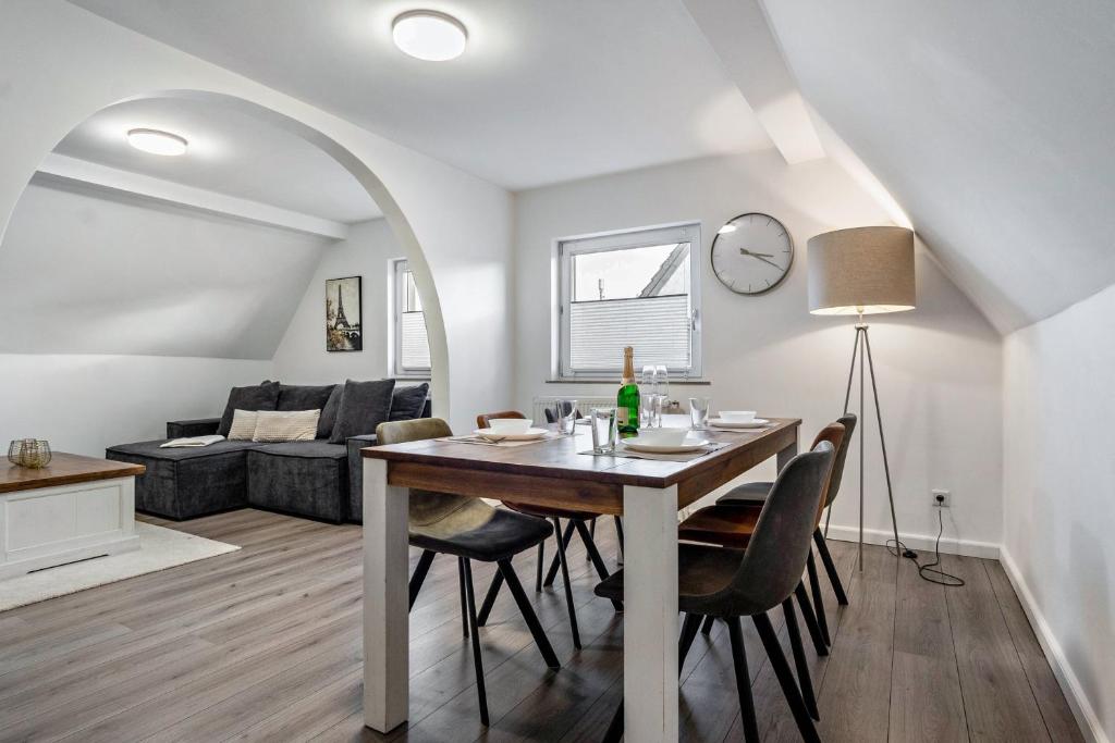 a dining room and living room with a table and chairs at Ferienwohnung zur Grenze in Gronau