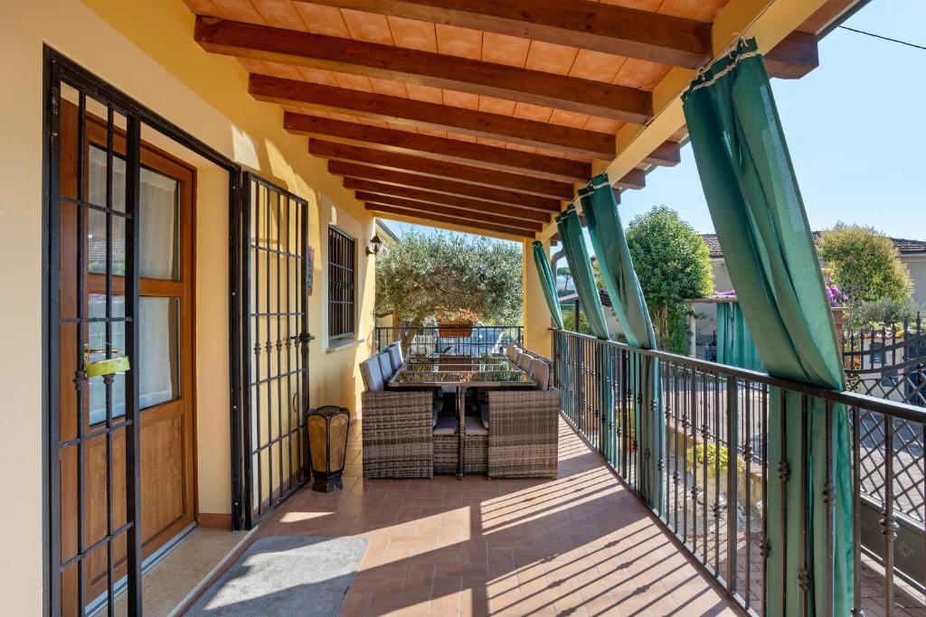 a patio with a table and chairs on a balcony at Villa Gardenia - Private Garden in Sarzana