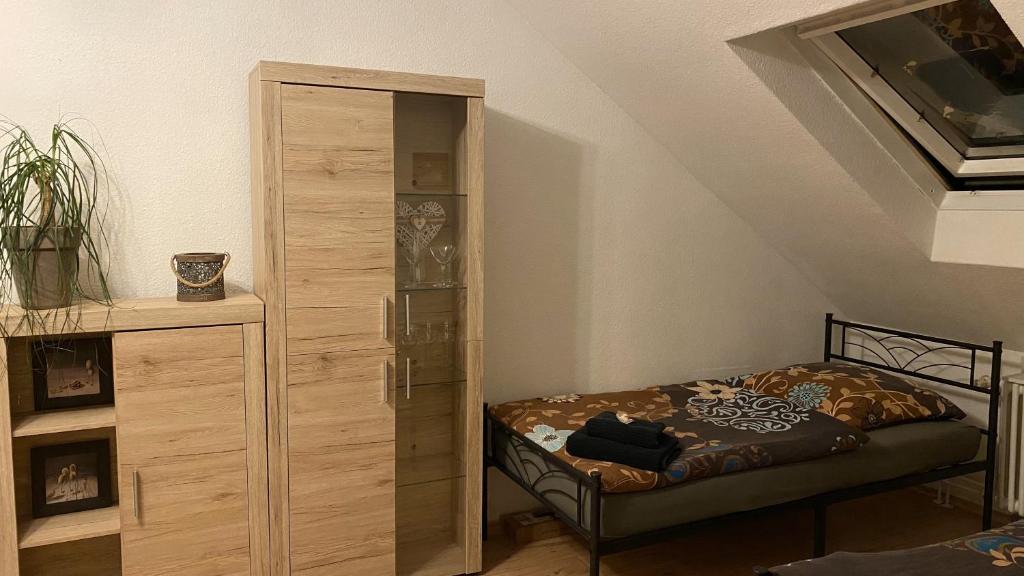 a bedroom with a bed and a large wooden cabinet at Appartment nahe Galopprennbahn in Iffezheim
