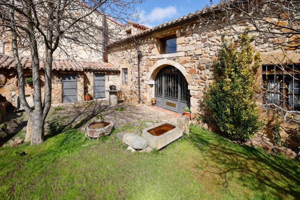 a stone house with a door and a yard at El Molino del pepe in Almajano
