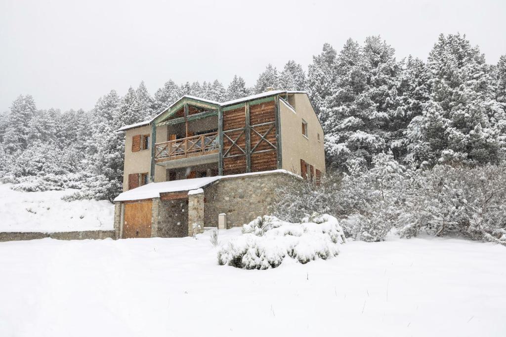 a house covered in snow with trees in the background at Chalet Pla Del Mir in Les Angles