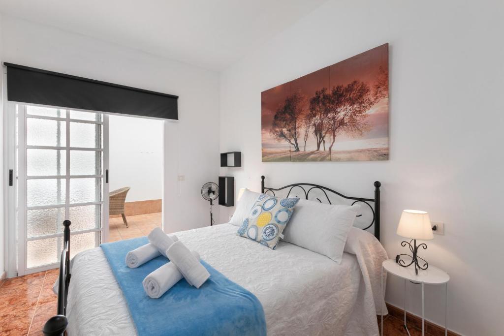 a bedroom with a large bed with a blue blanket at Arenas de Sal in La Mareta