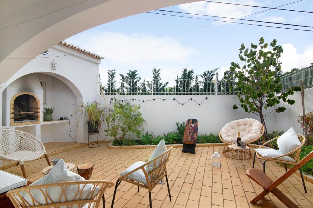 a patio with chairs and a white wall at Casa Judite in Lagoa
