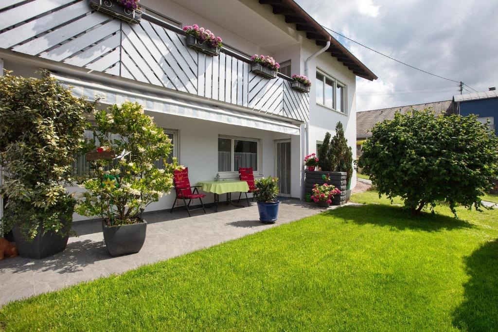 a house with a patio with a green lawn at Ferienwohnung Barbara in Karsau