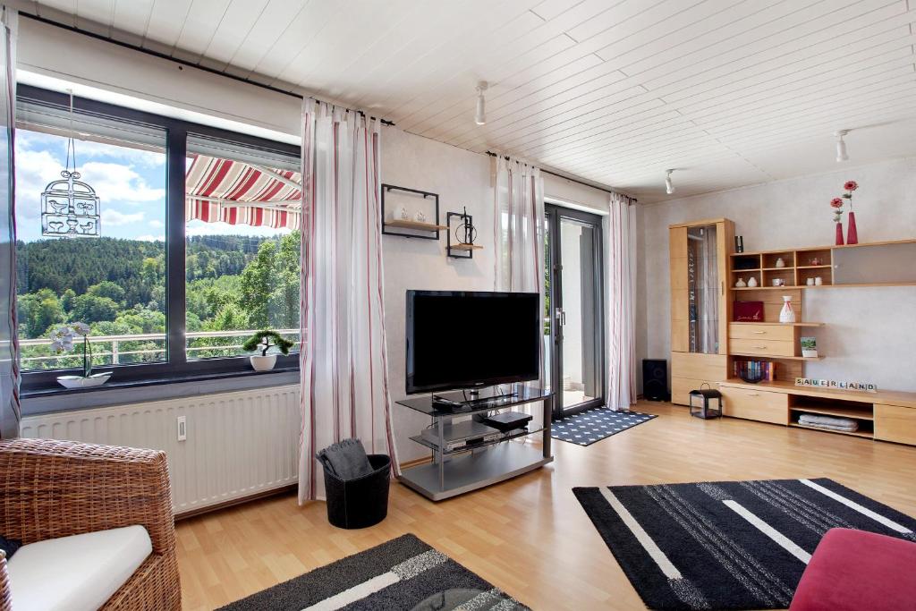 a living room with a television and a large window at Ferienwohnung Lux in Plettenberg