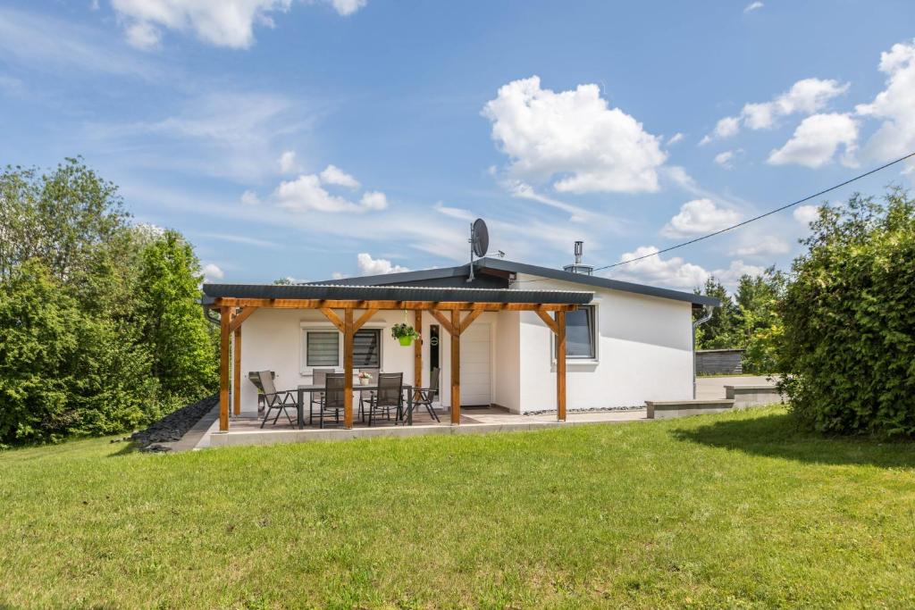 a cottage with a patio and grass yard at Ferienhaus Bornwiese in Schwalmtal
