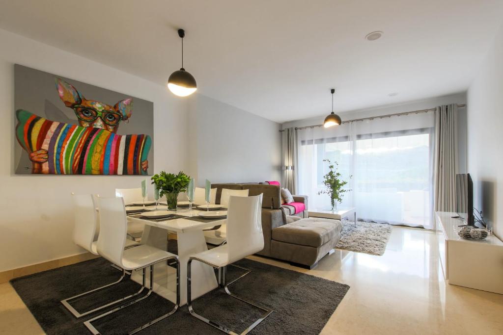 a living room with a table and chairs and a couch at 2-bed apt in Capanes del Golf in Benahavís