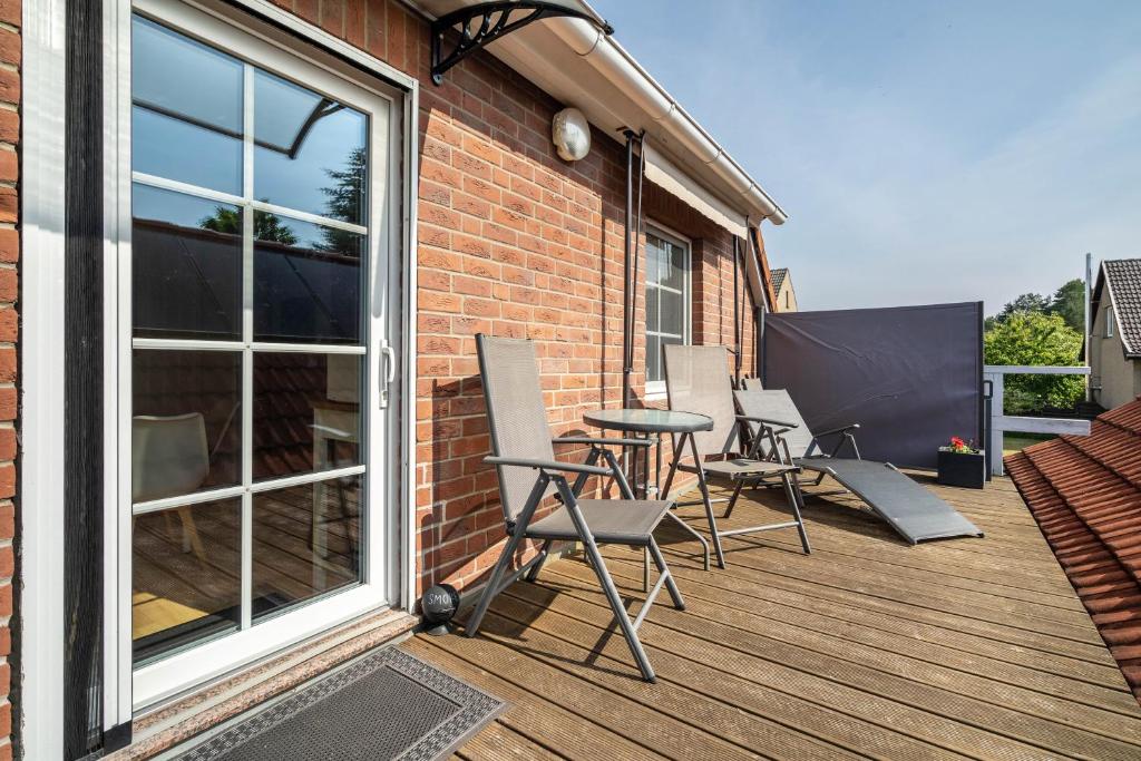 a patio with chairs and a table on a deck at Ferienwohnung 2 Schulze in Neustrelitz
