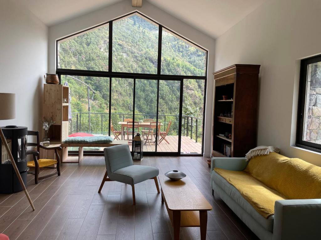 a living room with a couch and a large window at Maison Gaia in Valdeblore