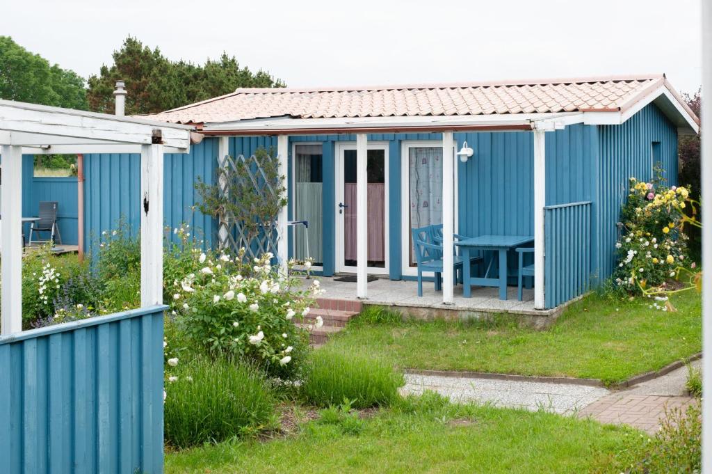 a blue cottage with a porch at Möve Aba Bungalow 65 in Rerik