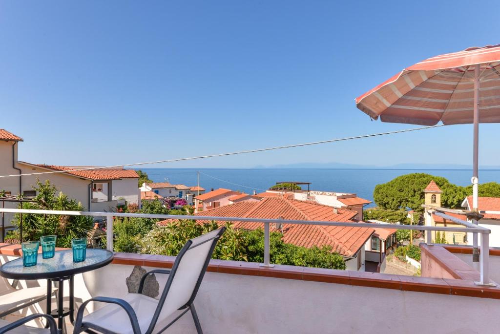 a balcony with a table and chairs and a view of the ocean at Appartamento con vista mare Chiessi in Chiessi