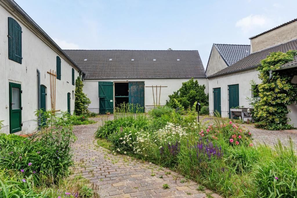 a garden with a brick path between two buildings at Vierseitenhof mit Pool in Ziesar
