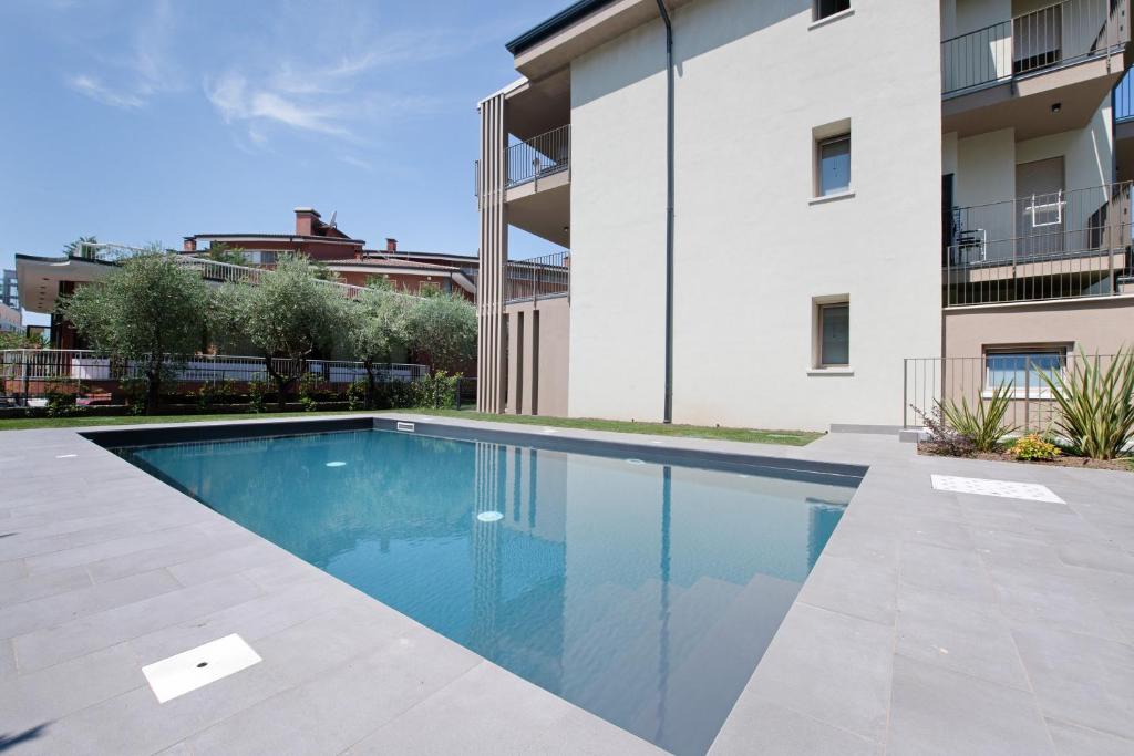 a swimming pool in front of a building at Residence Eleonora in Garda