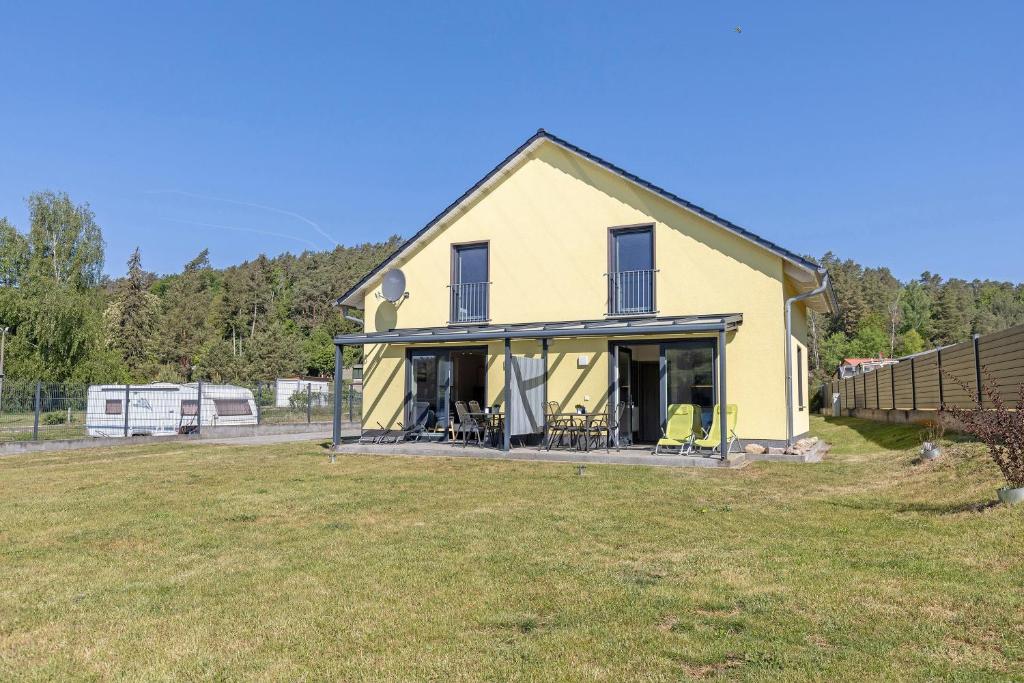 a yellow house on a field with a yard at Ferienanlage am Seerand in Joachimsthal