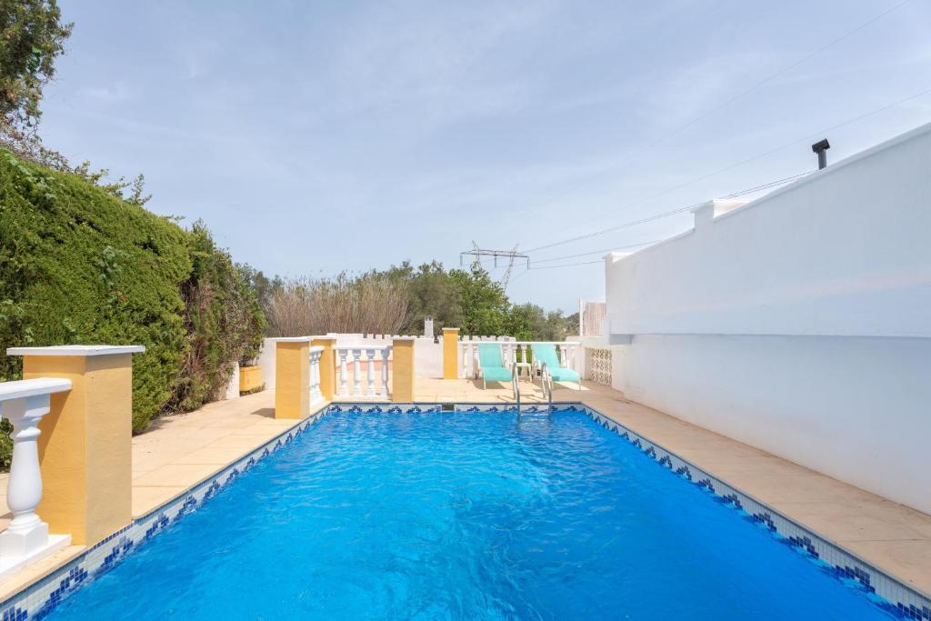 a swimming pool with blue water in a backyard at Villa Casablanca Apartment in Torrent