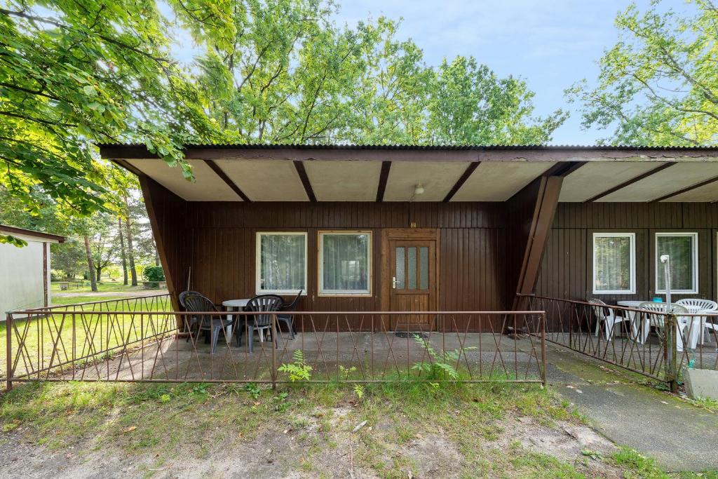 a house with a porch with chairs and tables at Bungalow 2 - Kimbucht in Reichendorf