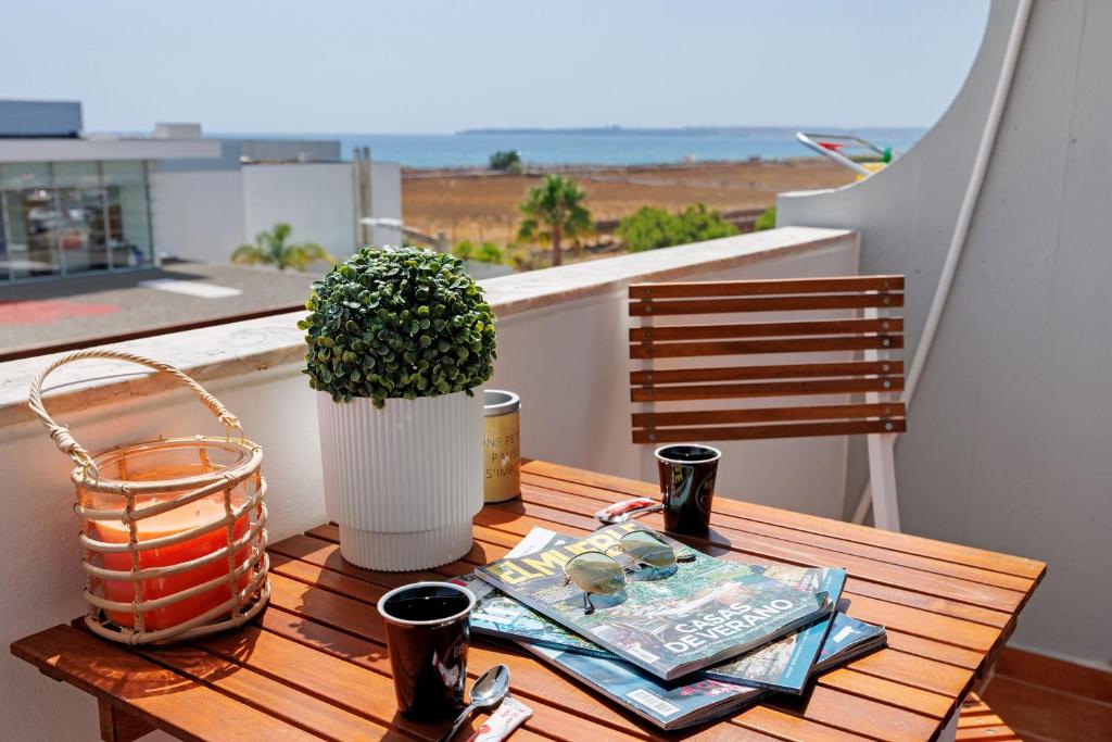 a table with a book and a vase on a balcony at Casa Pôr do Sol in Alvor