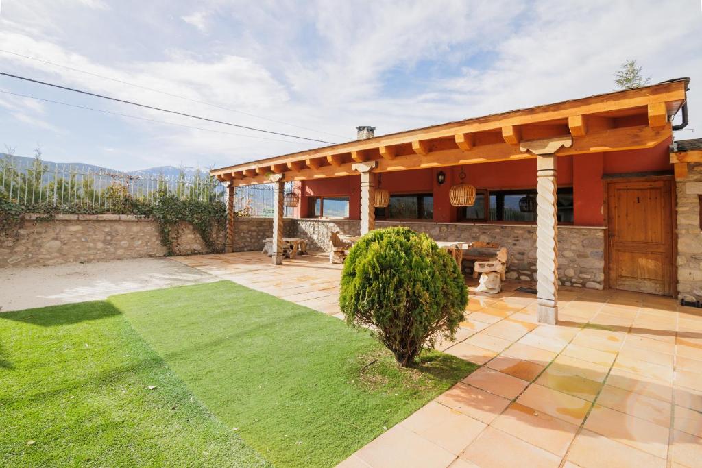 a house with a pavilion with a green lawn at Can Ricart in Puigcerdà