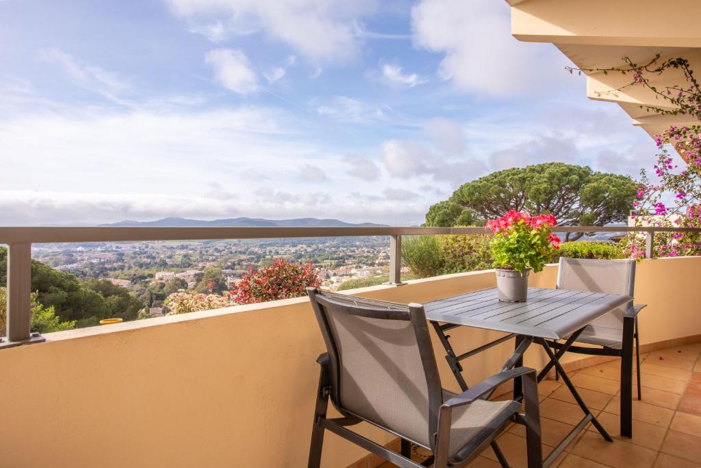 a table and chairs on a balcony with a view at Le Mas Berliat N°7 in Bormes-les-Mimosas