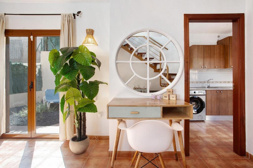 a desk with a mirror and a plant in a room at Villa Charlotte in La Oliva