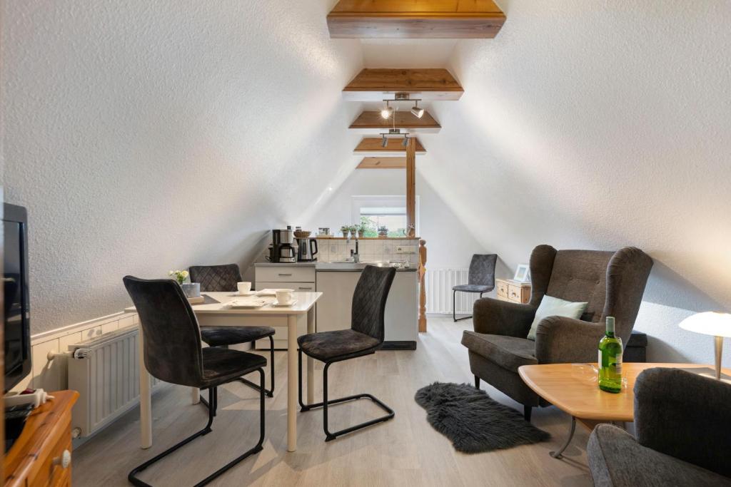 a living room with chairs and a table and a kitchen at Ferienwohnung Tüchsen in Klixbüll