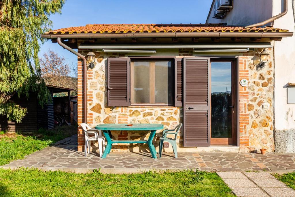 a table and two chairs in front of a house at Le Gerlette - La Capanna in Braccagni