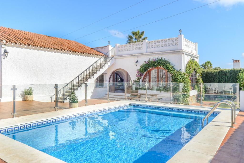 a swimming pool in front of a house at Villa Jardin Tropical in Manilva