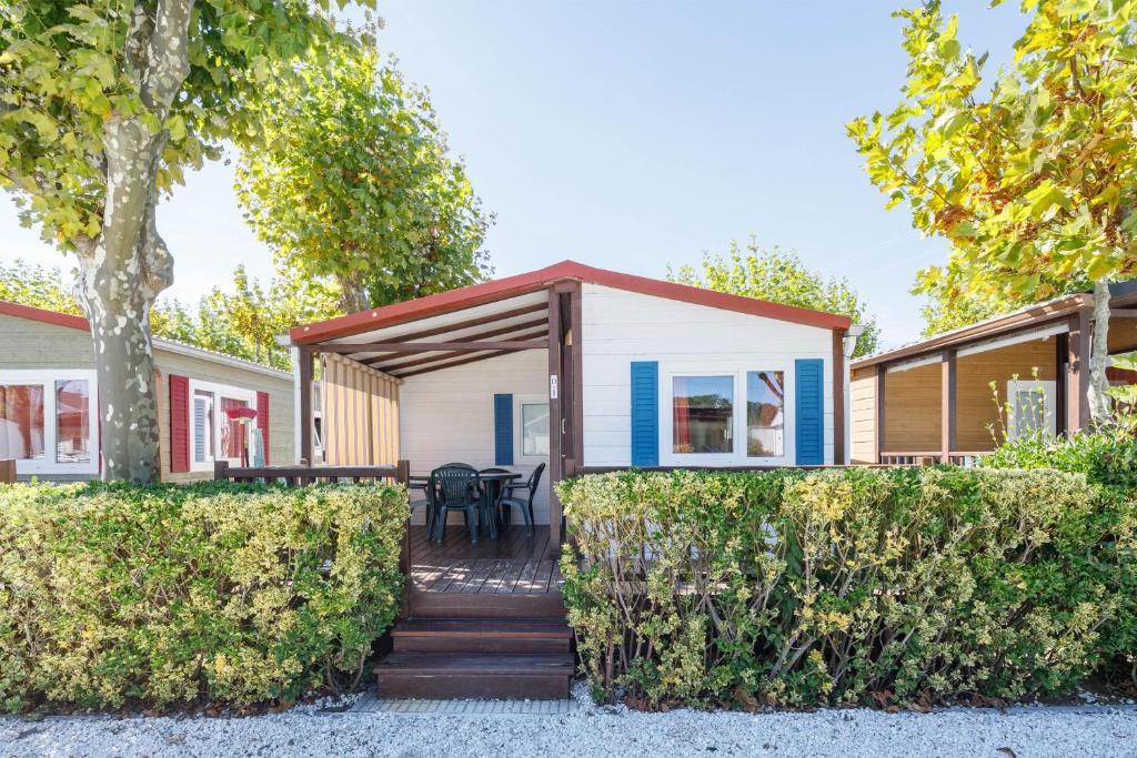 a home with a wrap around porch with bushes at Bungalow D in Pontevedra