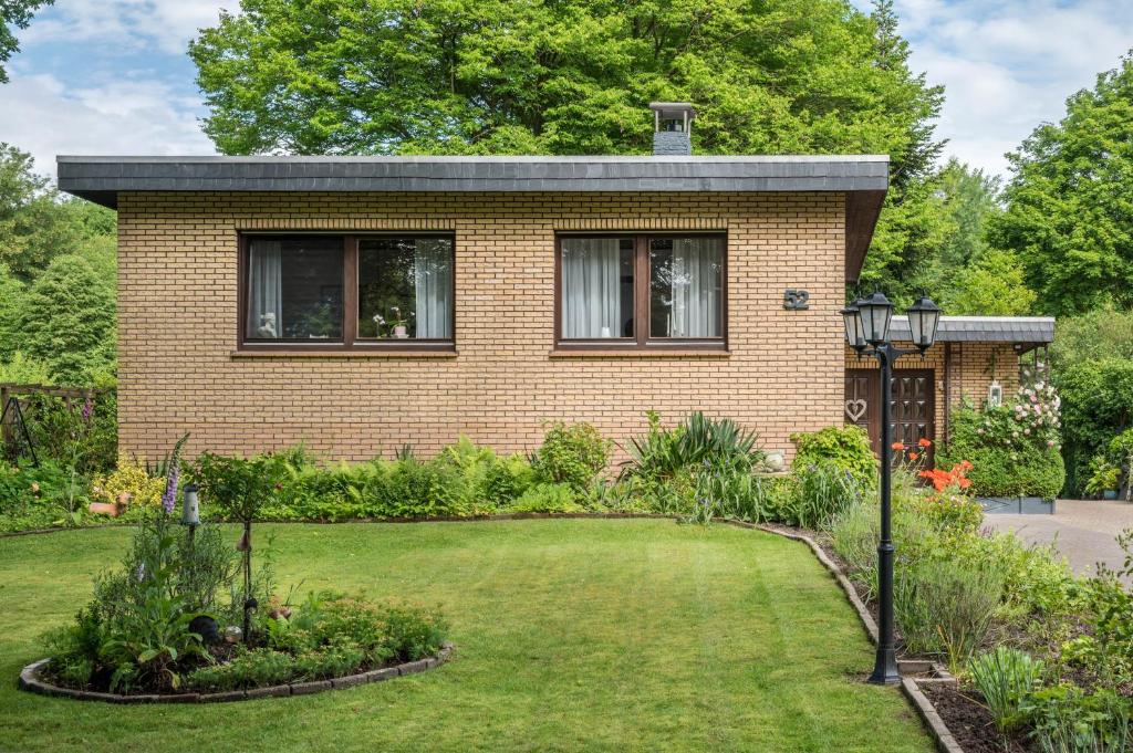 a brick house with a garden in front of it at Ferienwohnung Loy in Rastede