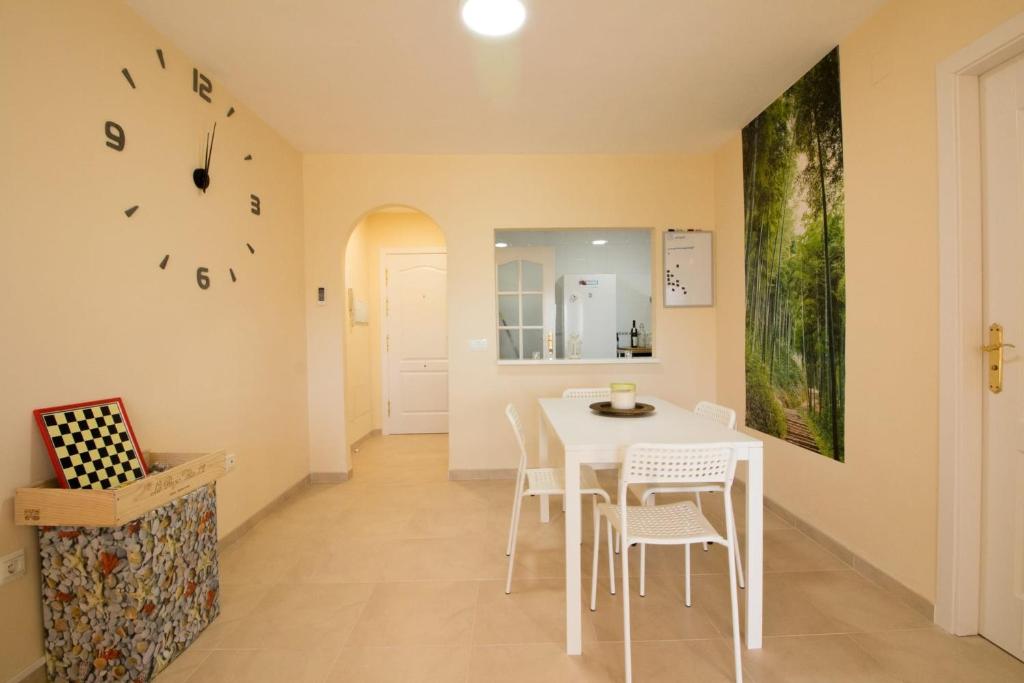 a dining room with a white table and chairs at Barlovento in Algarrobo