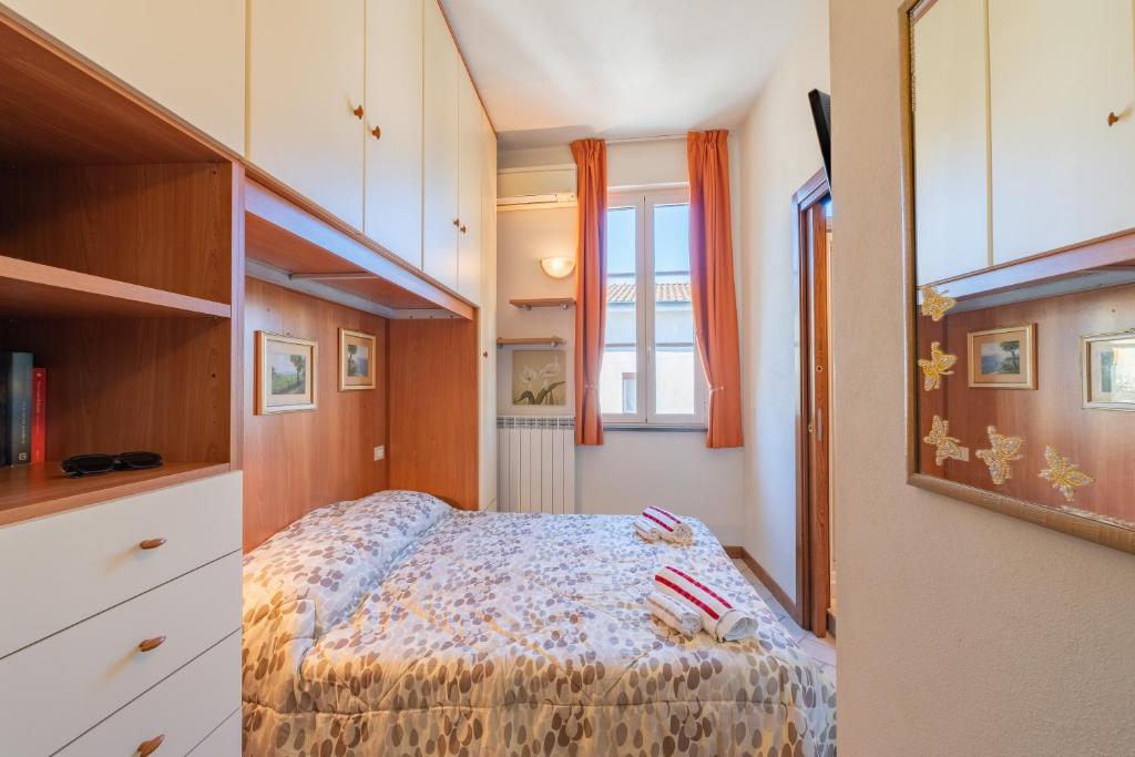 a small bedroom with a bed and a window at Casina La Torretta - By The Walls in Lucca