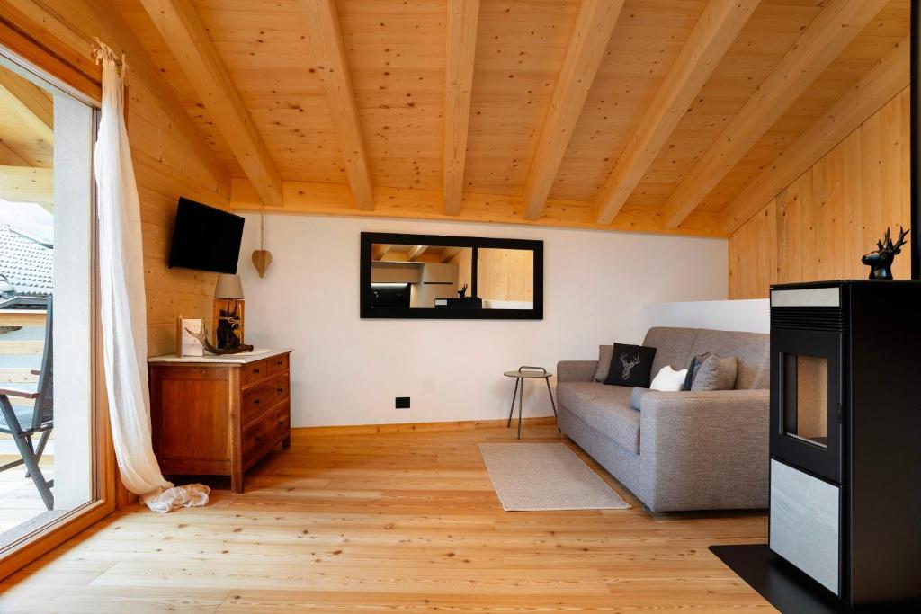 a living room with a couch and a tv at Bio Maso Nido Verde in Frassilongo